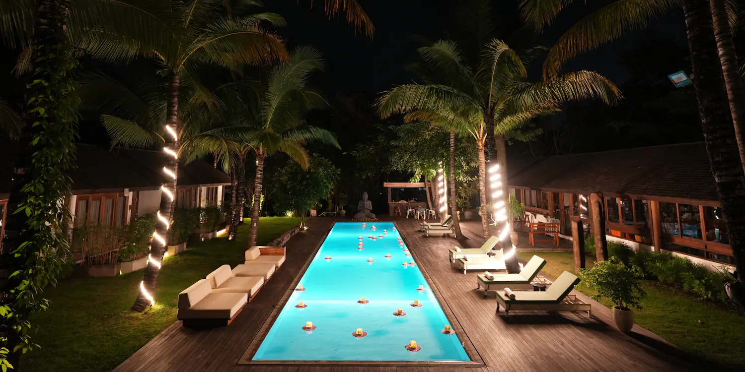 A terrace swimming pool lit from within on a still night.