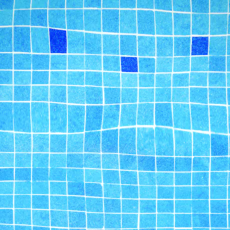 Close detail of glazed mosaic tiles lining a pool wall.