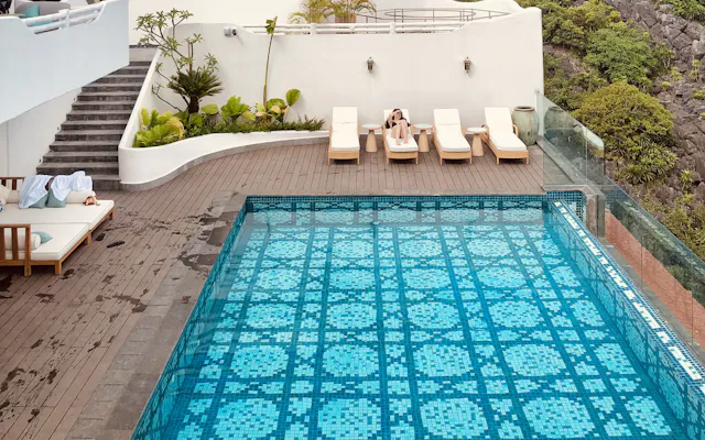 A pool edge meeting a paved terrace.