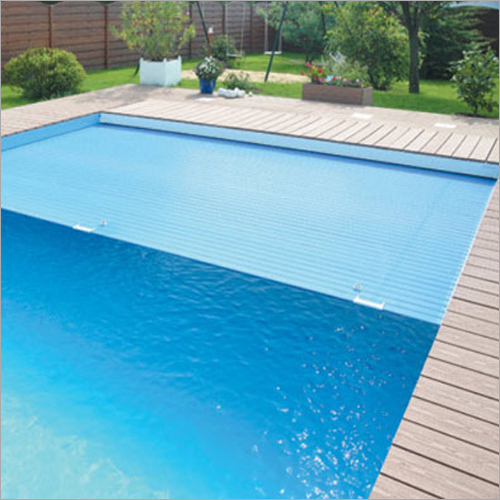 A slatted cover drawn part-way across a swimming pool.