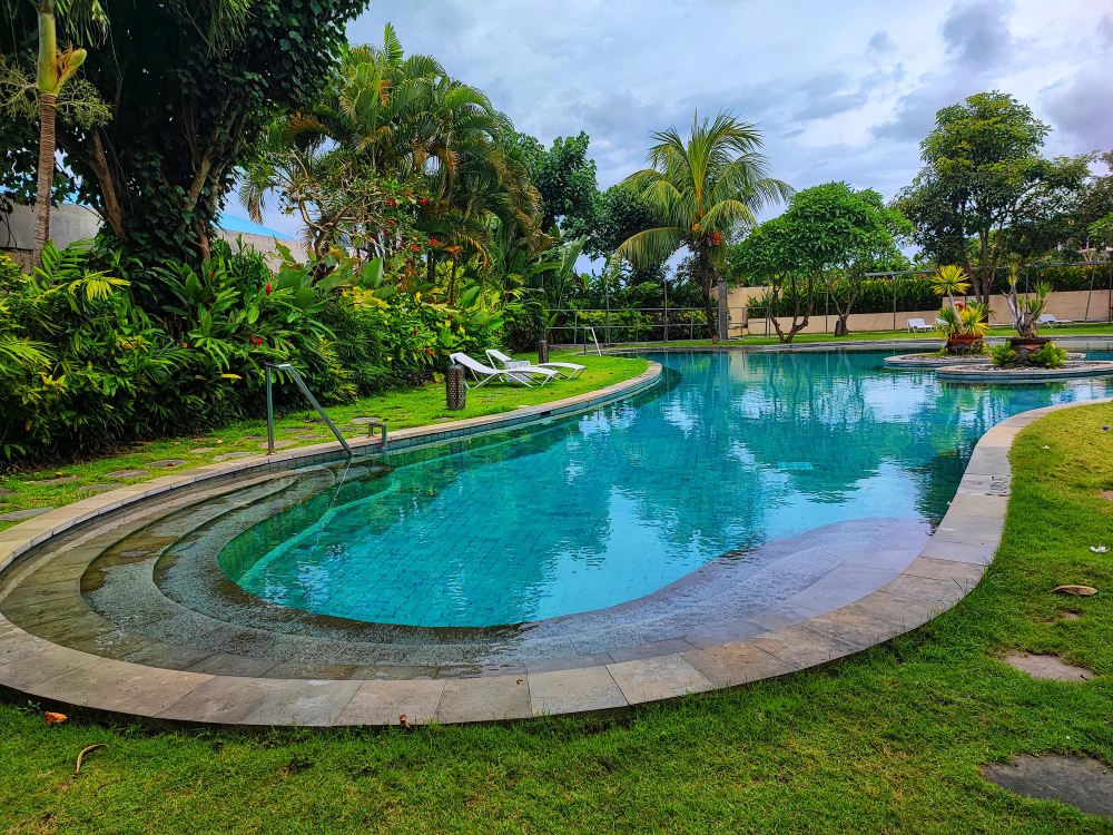 A free-form lagoon pool with a natural edge and planting around it.