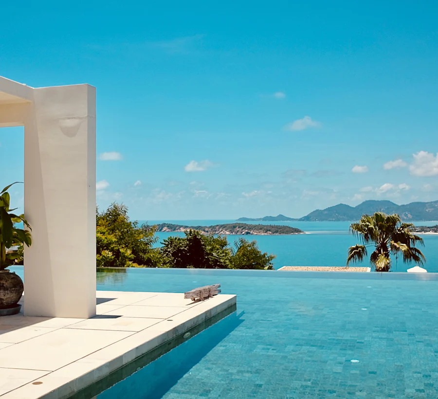 A vanishing-edge pool whose water line meets the sea beyond it.